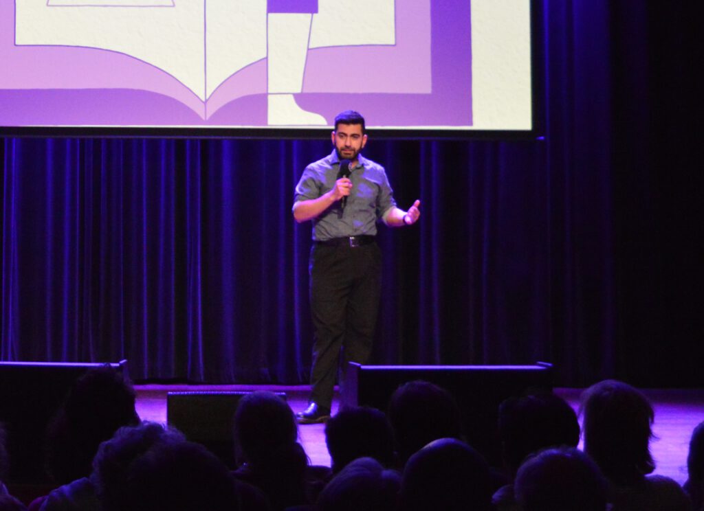 Ik sta te presenteren op een podium met een microfoon in mijn hand